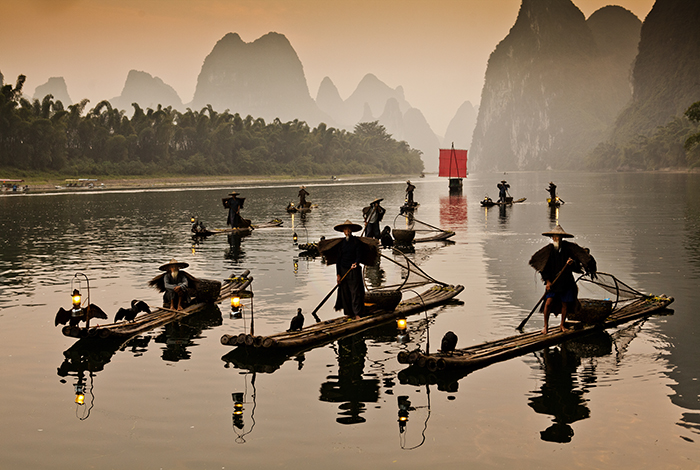 Xingping Guangxi China Kina 2013 09 15 kinesisk båt med rött segel på Li floden Traditionella kinesiska fiskare på Li Floden bambuflotte bambubåt skarv skarvar fotogenlampor sockertoppsberg flod ---- FOTO : JOACHIM NYWALL KOD 0708840825_1 COPYRIGHT JOACHIM NYWALL ***BETALBILD*** Redovisas till NYWALL MEDIA AB Strandgatan 30 461 31 Trollhättan Prislista enl BLF , om inget annat avtalas.